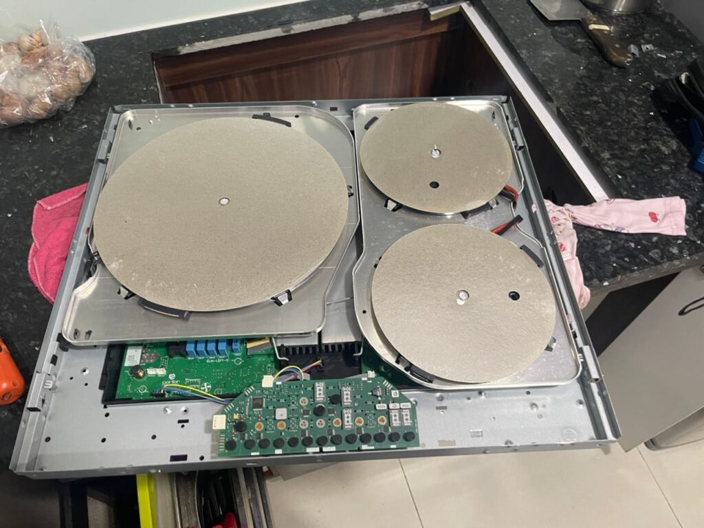 Sửa Bếp Từ Tại Nhà Hà Nội Uy Tín | Báo Giá Trực Tiếp, Xử Lý Dứt Điểm Thợ sửa bếp từ tại nhà hà nội của Điện Lạnh Bách Khoa đang kiểm tra bo mạch