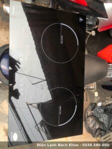Kỹ thuật viên tháo máy kiểm tra cuộn cảm và bo mạch bếp từ