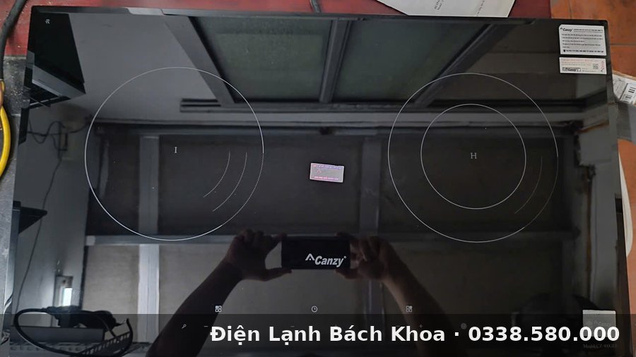 Top Dịch Vụ Sửa Bếp Từ Uy Tín Nhất Hà Nội 2026 Kỹ thuật viên tháo máy kiểm tra cuộn cảm và bo mạch bếp từ