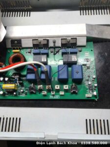 Kỹ thuật viên tháo máy kiểm tra cuộn cảm và bo mạch bếp từ
