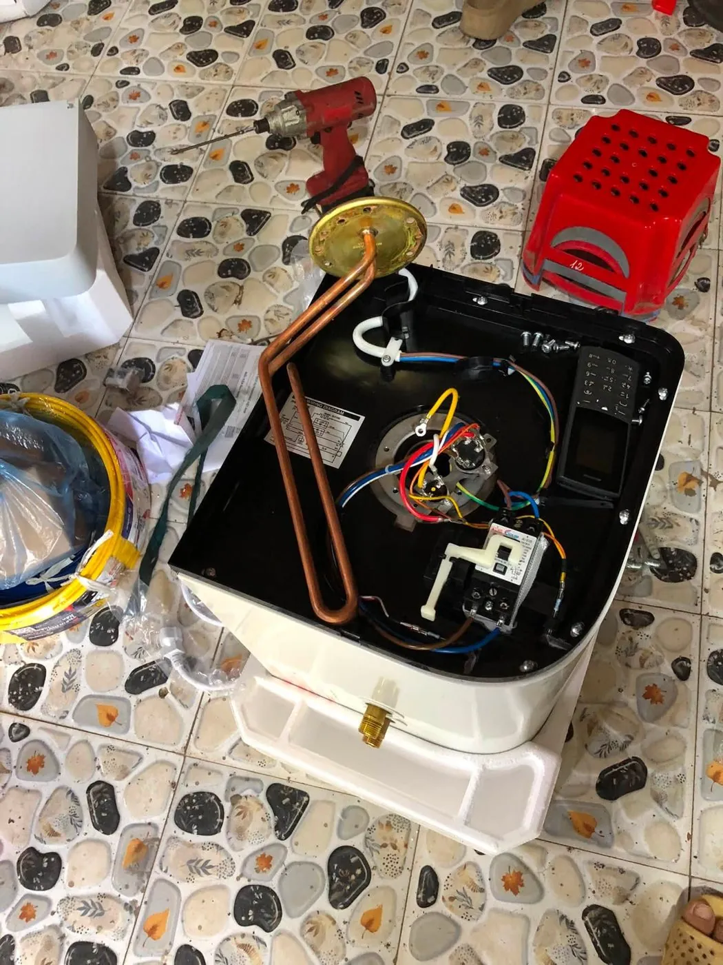 Bình nóng lạnh mở nắp khi lắp mới, thấy rõ thanh đốt đồng, rơ le và cụm dây điện màu