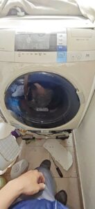 Thợ sửa máy giặt sấy Hitachi Big Drum nội địa Nhật, máy đã được kích lên khỏi chân đế